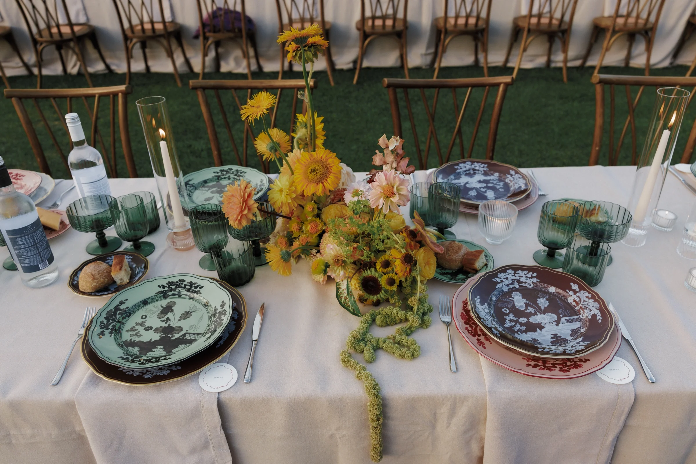 Outdoor tablescape at golden hour with sunflowers, dahlias and painted porcelain.