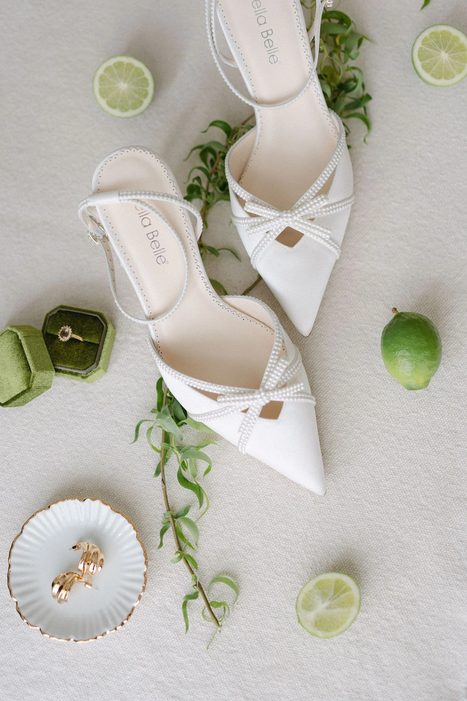 Bridal shoes and rings styled with lime and trailing greenery